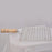 Barbecue grill with square stainless steel mesh and wooden handle.
